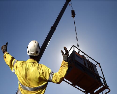 crane lifting an industrial compressor