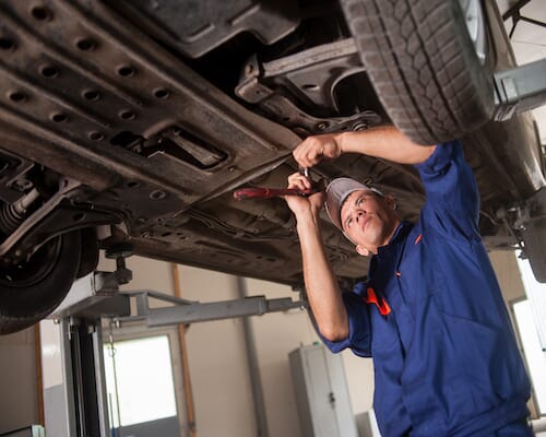 mechanic working on car above him
